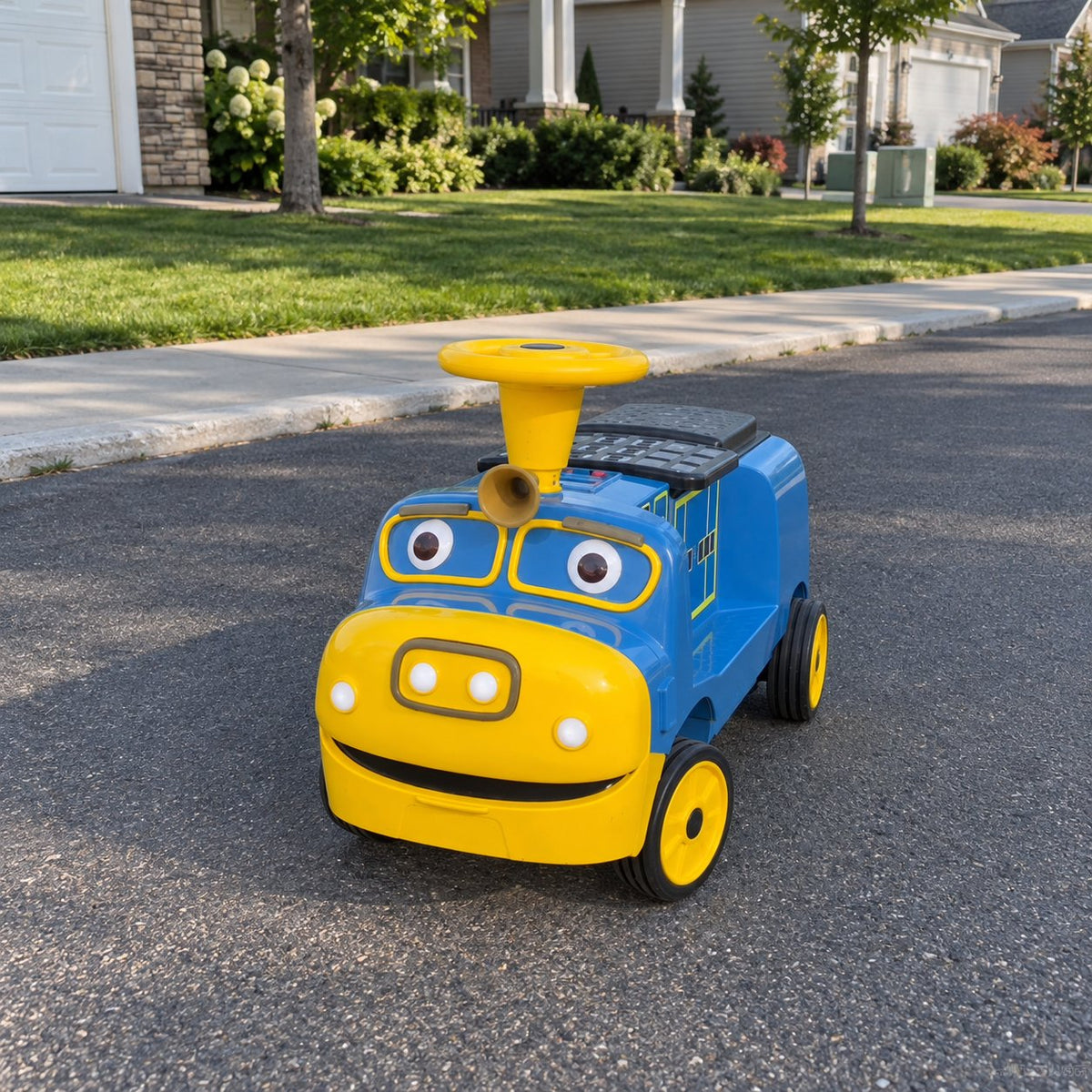 Blue ELEMARA Chuggington ride-on train parked on a sunny suburban street