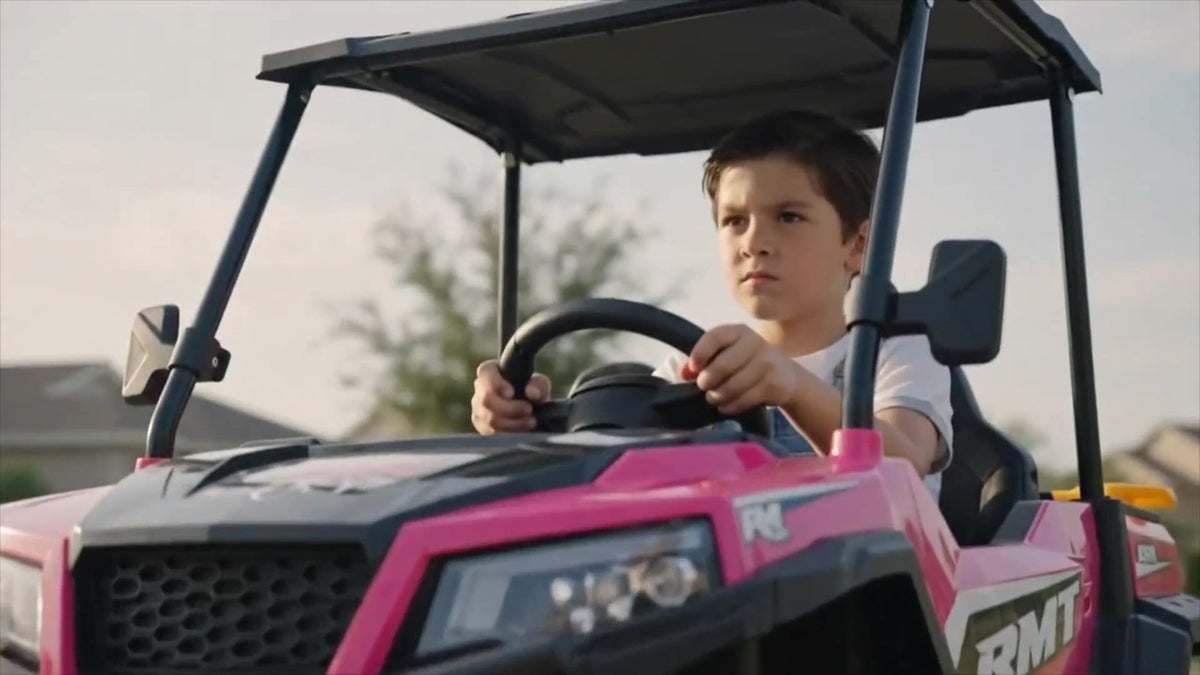 Boy steering the ELEMARA 24V 2-seater kids ride-on truck under its sun canopy