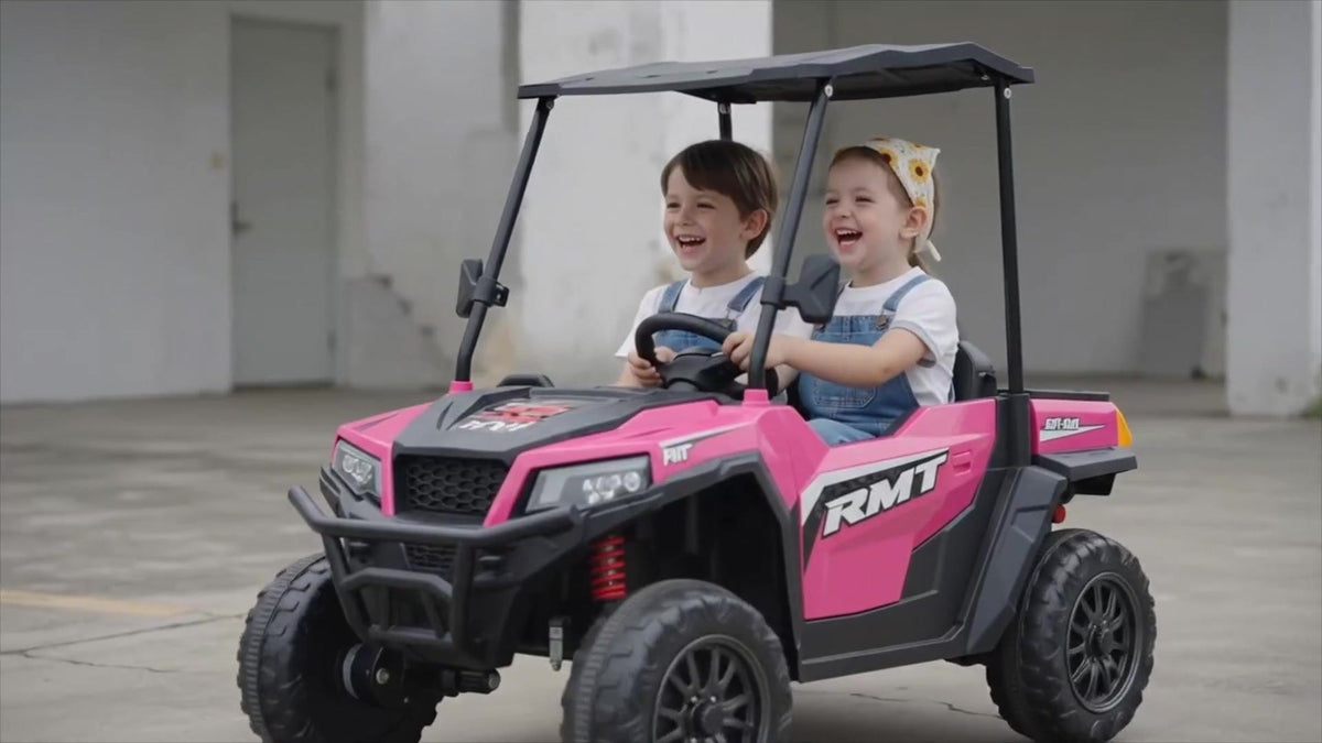 Girl driving the ELEMARA 24V 2-seater ride-on truck in front of a garage